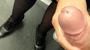 O MILF amatoare în ciorapi și lenjerie intimă se masturbează cu penisul soțului ei într-un lift public