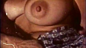 A big ass blonde gets her tits and pussy licked by a man with long sideburns in a classic porn video