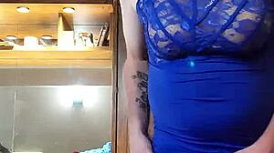 Crossdressing hottie i en blå kjole driller med sine bryster og pik