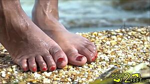 เด็กหนุ่มและเด็กสาวประหลาดได้รับการนวดเท้าเปียกบนชายหาด