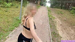ブロンドの女性が公園で屋外でエクササイズをし、裸の体をさらけ出し、跳ねる胸を見せます。